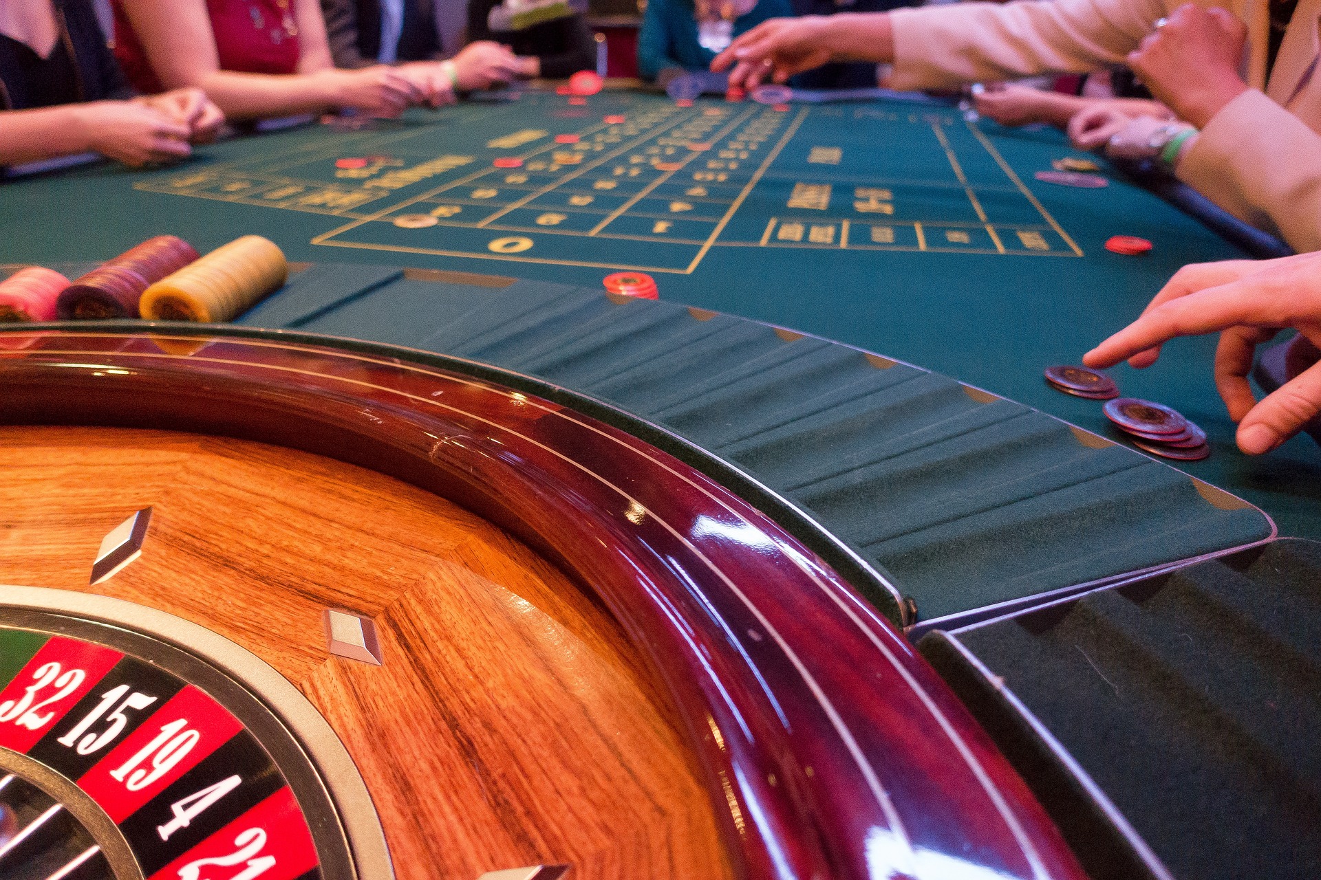Roulette table with people placing their bets.